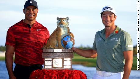 Tiger Woods poses with Hovland and the trophy after Hovland won the Hero World Challenge.