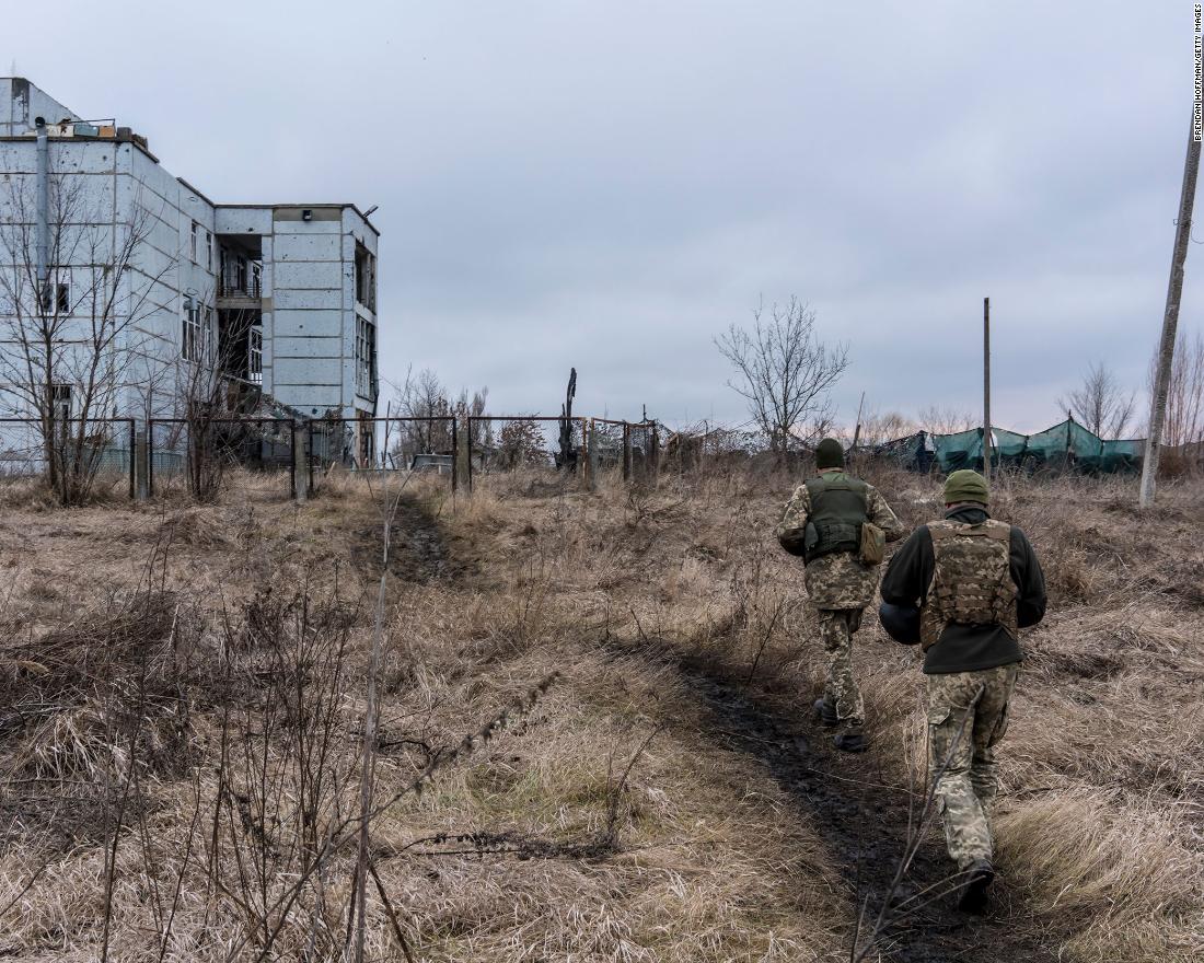 Ukrainian soldiers walk toward a destroyed building in Marinka on December 8.
