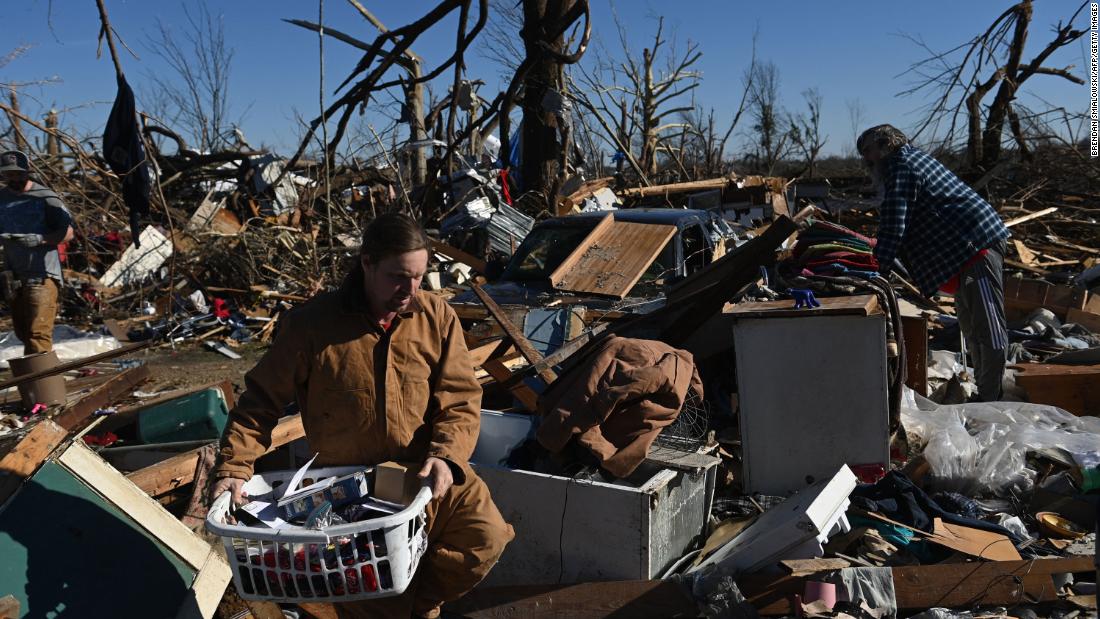 People gather belongings from a damaged home on December 12 in Mayfield, Kentucky.