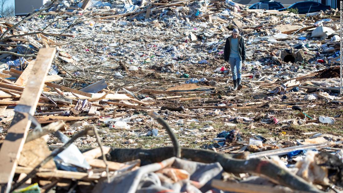A man walks through the wreckage of houses in a Bowling Green, Kentucky neighborhood on Sunday, Desember 12, after extreme weather hit the region.