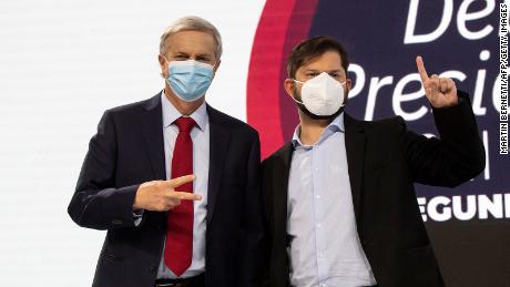 Chilean presidential candidates Gabriel Boric (对) and Jose Kast pose before a debate in Santiago, Chile on December 10. 