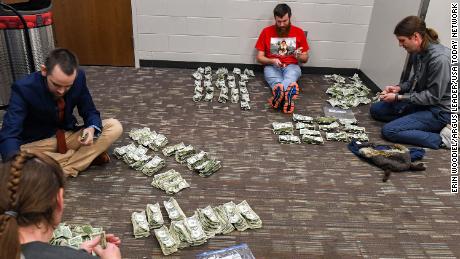 Schoolteachers count the dollar bills they collected at the Sioux Falls Stampede game. 