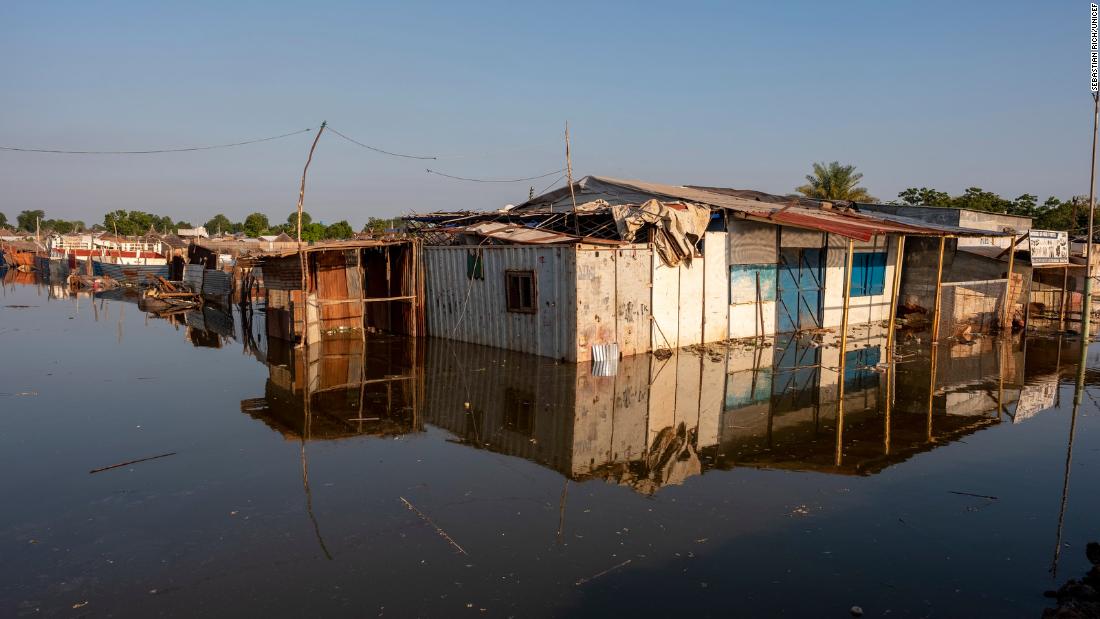 Buildings in Bentiu are submerged in water. Many people are displaced and living in shelters made from sticks and trash.