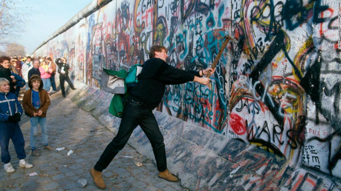 A demonstrator pounds away at the Berlin Wall in November 1989. Gorbachev renounced the Brezhnev Doctrine, which pledged to use Soviet force to protect its interests in Eastern Europe. In September, Hungary opened its border with Austria, allowing East Germans to flee to the West. After massive public demonstrations in East Germany and Eastern Europe, the Berlin Wall fell on November 9.