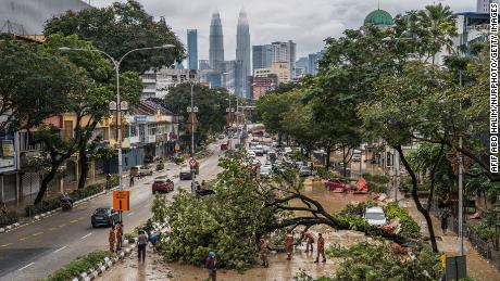 Firemen remove fallen trees caused by floodwaters in Kuala Lumpur, Malaysia, on December 19.