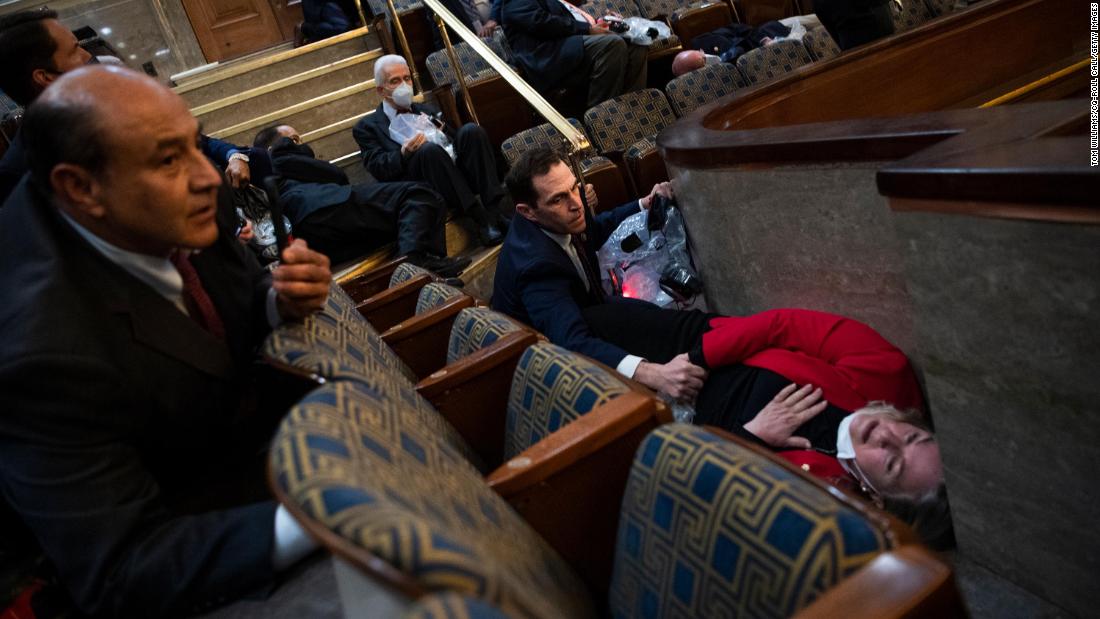 米国の担当者. Jason Crow, a Democrat from Colorado, comforts US Rep. Susan Wild, a Democrat from Pennsylvania, while taking cover in the House chamber.