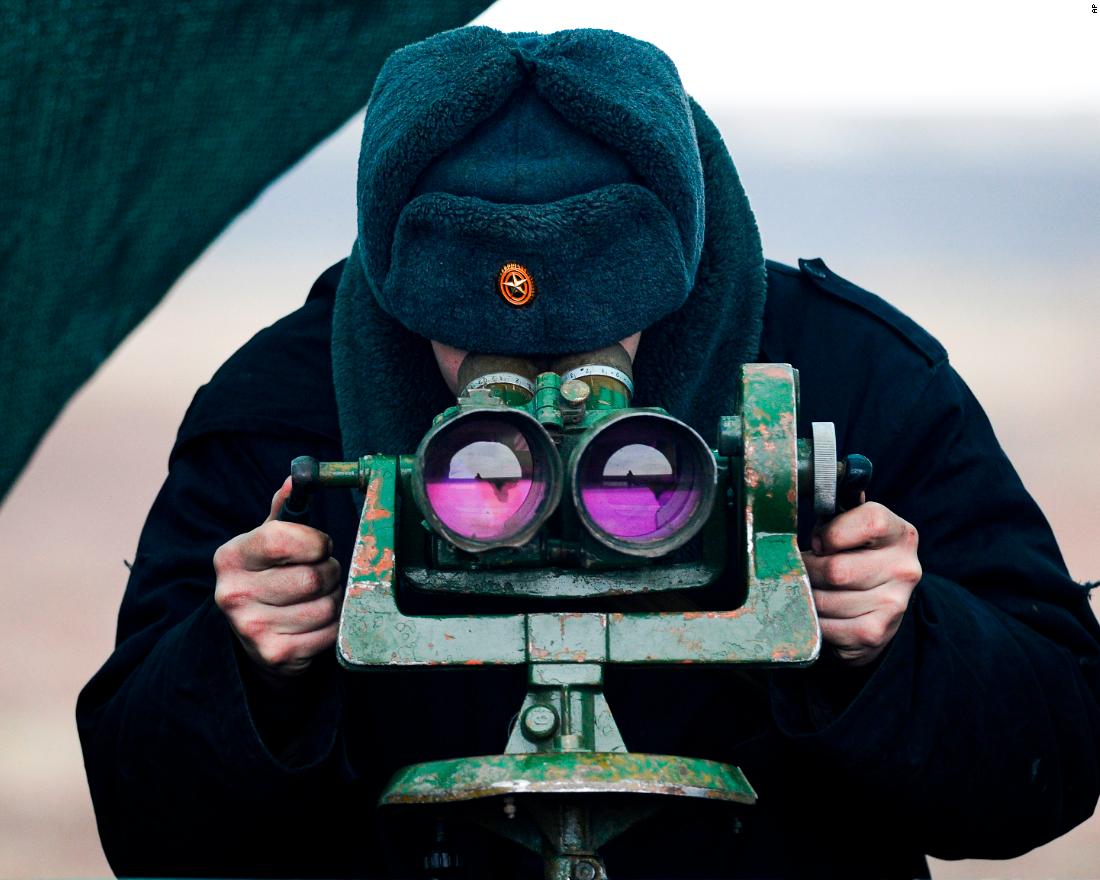 A Russian serviceman looks through binoculars as he takes part in drills at the Kadamovskiy firing range on Tuesday, dicembre 14.