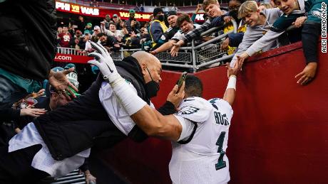 Fans fall onto Philadelphia Eagles quarterback Jalen Hurts as the railing collapsed following the end of a game on Sunday in Landover, Maryland. 