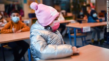 A girl wears winter clothes and a face mask in her aerated classroom at the Petri primary school in Dortmund, western Germany, einde November.
