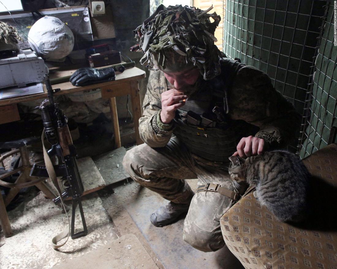 A Ukrainian Military Forces servicemen strokes a cat in a trench at the front line with Russia-backed separatists near to Avdiivka, southeastern Ukraine, a gennaio 9.