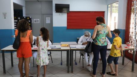 Families arrive at a Covid-19 vaccination center in Volta Redonda, ブラジル, 月曜日に. 