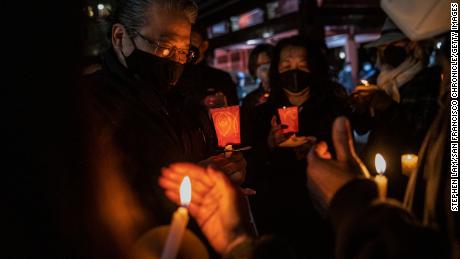 Philip Lai, links, of South San Francisco, at a candlelight vigil for Michelle Alyssa Go at Portsmouth Square in San Francisco.