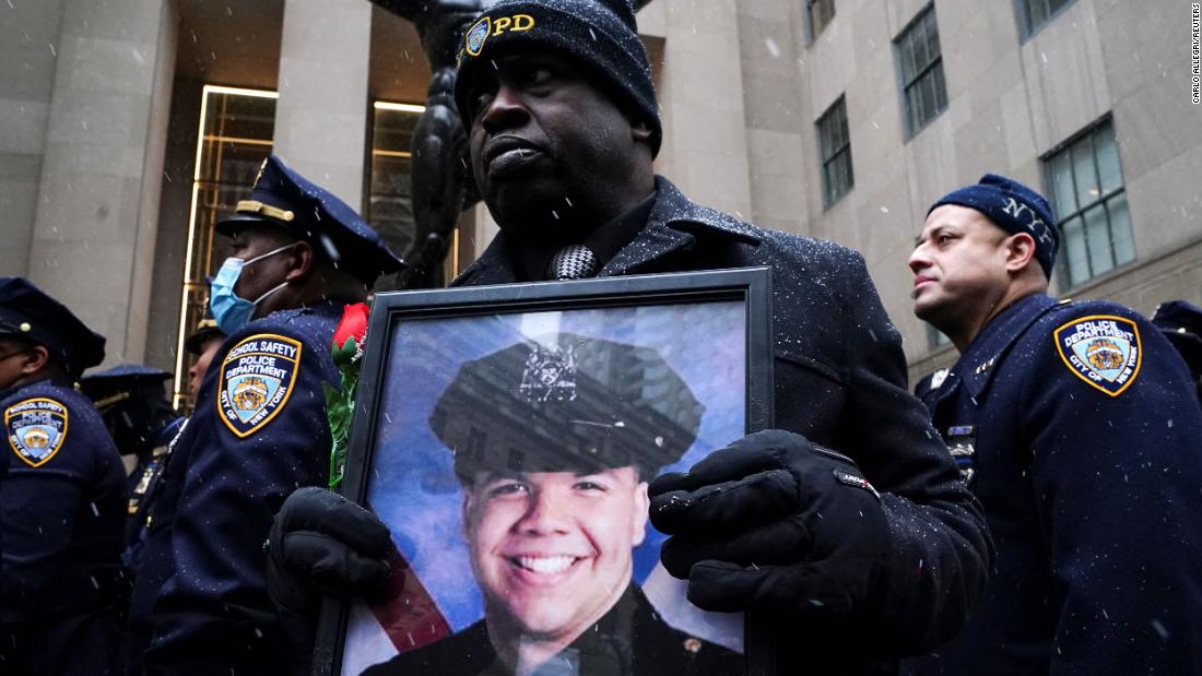 A man holds a picture of Rivera during his funeral service.