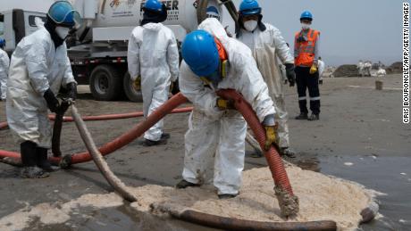 Cleaning crews work to remove oil from a beach in the Peruvian summer resort town of Ancón, in northern Lima, op Januarie 20.