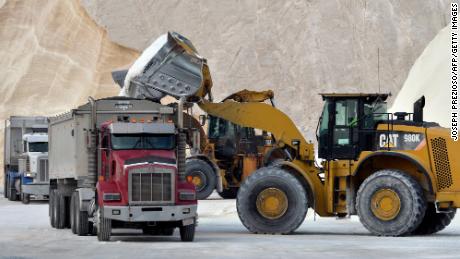A bulldozer loads trucks with salt at Eastern Salt in Chelsea, Mass., op Januarie 28, 2022.