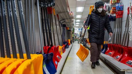 A woman carries a new shovel at Woodside Ace Hardware in Winthrop, Mass., op Januarie 28, 2022.