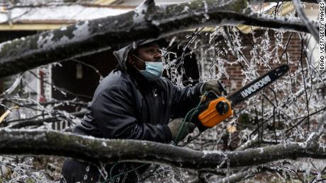 A man works to clear a downed tree on February 3 in Memphis, Tennessee.