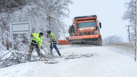 Crews from the New Hampshire Department of Transportation remove debris from a fallen tree on Route 9, in Chesterfield, N.H., after an early morning ice storm covered the area on Friday, Feb. 4, 2022.  A major winter storm that already cut electric power to about 350,000 homes and businesses from Texas to the Ohio Valley was set to leave Pennsylvania and New England glazed in ice and smothered in snow. (Kristopher Radder /The Brattleboro Reformer via AP)