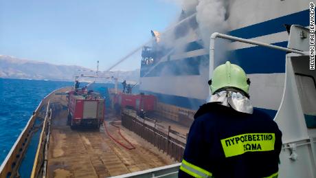 Firefighters try to extinguish the flames engulfing the burning ferry.