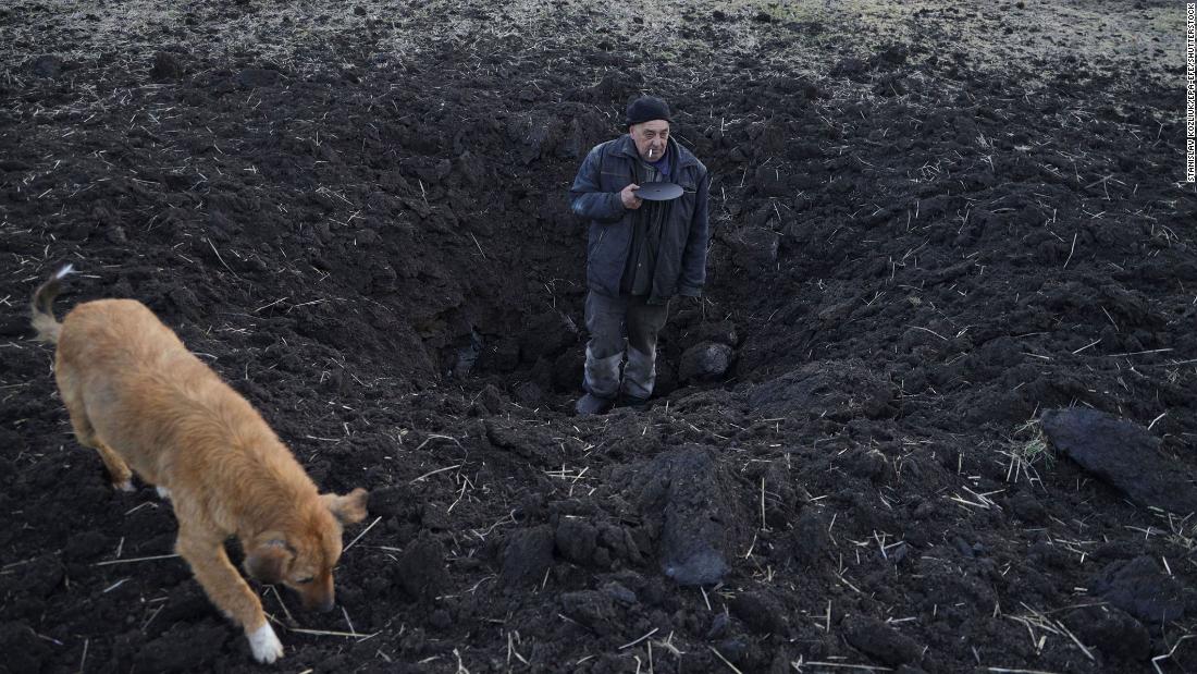 A local resident shows the depth of a crater from shelling in a field behind his house in the village of Tamarchuk, Ucraina, in febbraio 20.