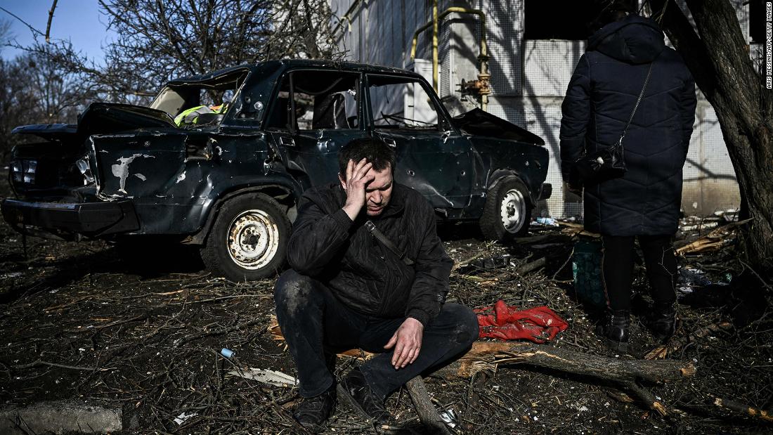 A man mourns after an airstrike reportedly hit an apartment complex in Chuhuiv on February 24.