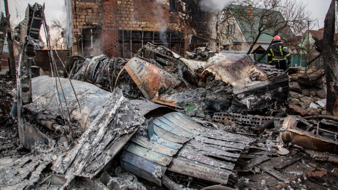 A firefighter walks between the ruins of a downed aircraft in Kyiv on February 25. 