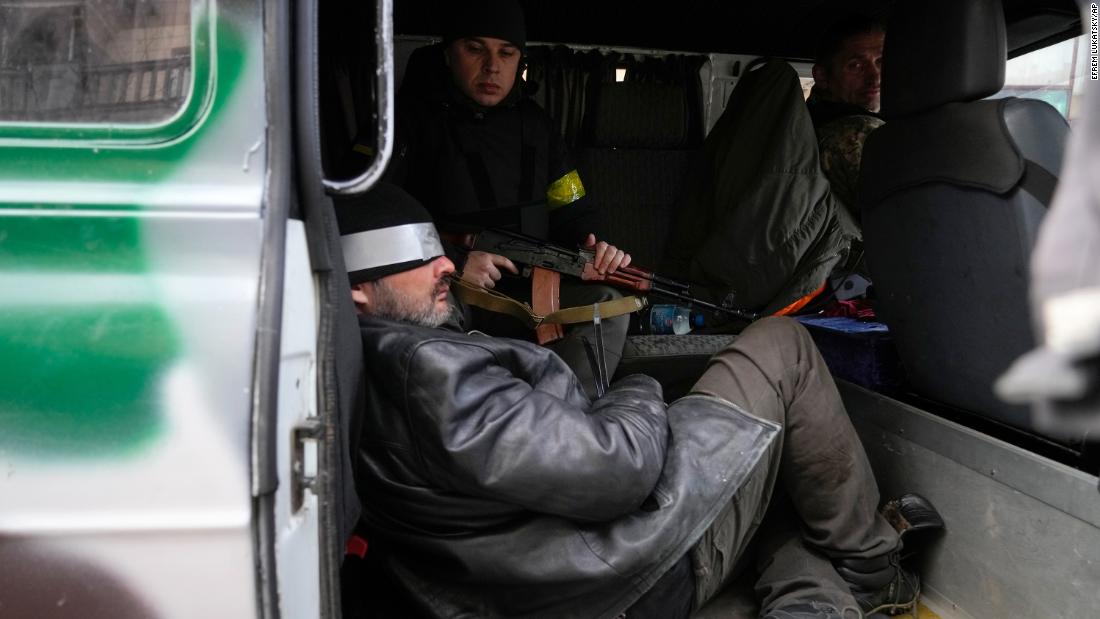 Ukrainian troops in Kyiv escort a prisoner February 27 who they suspected of being a Russian agent.