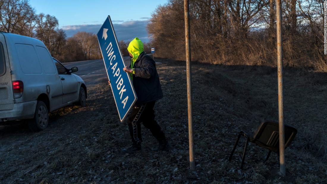 Following a national directive to help complicate the invading Russian Army&#39;s attempts to navigate, a road worker removes signs near Pisarivka, Ucraina, in febbraio 26.