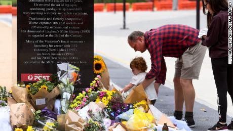 Flowers are placed at the base of a statue dedicated to Warne at the MCG. 