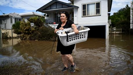 WOODBURN, AUSTRALIA - MARCH 07: Patria Powell walks through floodwater after salvaging items from her mother&#39;s flood-affected home March 07, 2022 in Woodburn, Australia.  Residents of northern New South Wales are still cleaning up following unprecedented storms and the worst flooding in a decade. (Photo by Dan Peled/Getty Images)