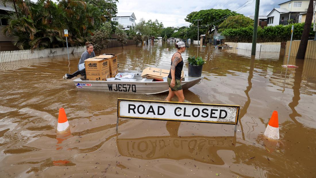 People use a boat to save items from their home in Brisbane, Australia, on March 3.