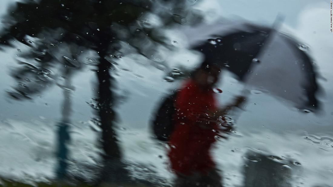 A person walks through rain at Manly Beach in Sydney on March 3.