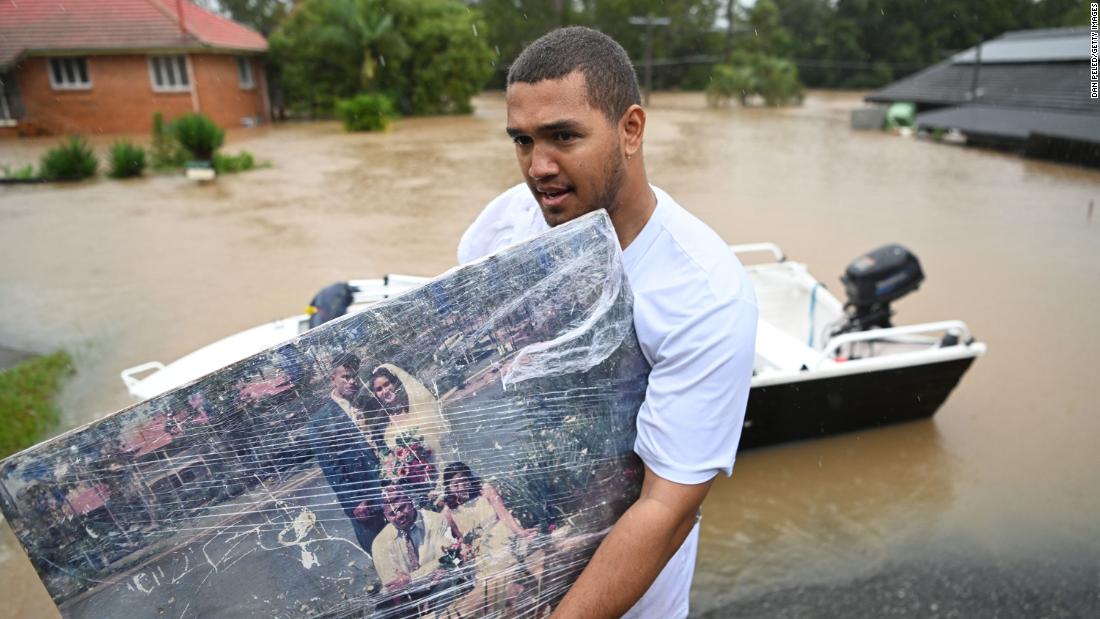A man carries a wedding photo as people evacuate homes in Goodna, Australia, on February 27.
