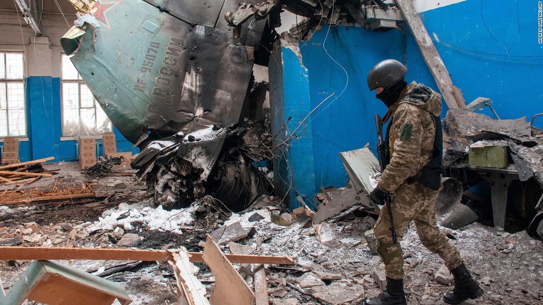 A Ukrainian serviceman walks past the remains of a Russian aircraft lying in a damaged building in Kharkiv, Oekraïne, op Maart 8.