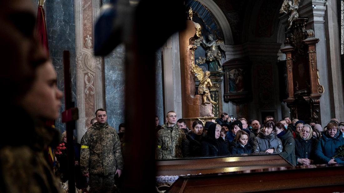 People pay their respects during &lt;a href =&quot;https://www.cnn.com/europe/live-news/ukraine-russia-putin-news-03-11-22/h_dfbf1eceb5e6d1274a1f5539b193b197&quot; target =&quot;_blank&ampquott;&gt;a funeral service&amltlt;/un&ampgtt; for three Ukrainian soldiers in Lviv on March 11. Senior Soldier Andrii Stefanyshyn, 39; Senior Lt. Taras Didukh, 25; and Sgt. Dmytro Kabakov, 58, were laid to rest at the Saints Peter and Paul Garrison Church. Even in this sacred space, the sounds of war intruded: an air raid siren audible under the sound of prayer and weeping. Yet no one stirred. Residents are now inured to the near-daily warnings of an air attack.