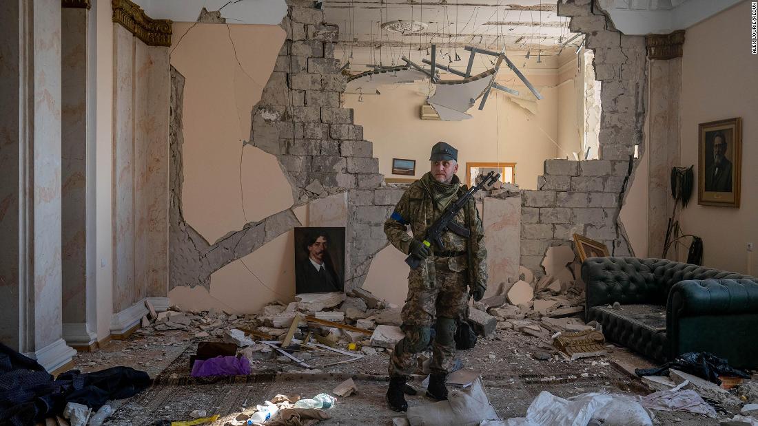 A Ukrainian soldier surveys a destroyed government building in Kharkiv on March 13.