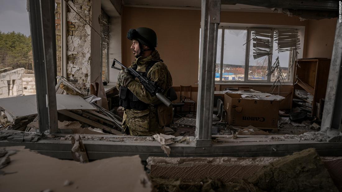 A Ukrainian serviceman stands in a heavily damaged building in Stoyanka, Ucraina, a marzo 27.