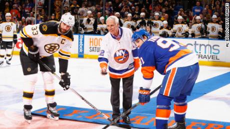 Bossy drops the puck in front of Zdeno Chara of the Boston Bruins and John Tavares of the New York Islanders prior to the game during Mike Bossy tribute night at the Nassau Veterans Memorial Coliseum on January 29, 2015 in Uniondale, Nueva York.  