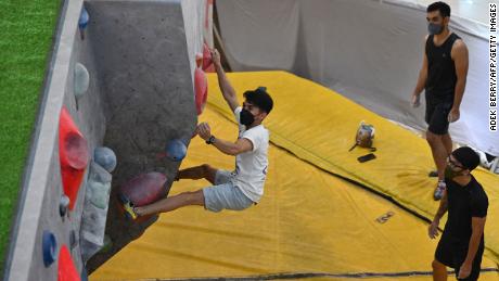 Bouldering is performed without ropes. Qui, a man practices at a Jakarta, Indonesia, mall.