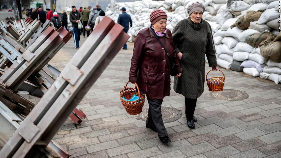 Women walk between sandbags and anti-tank barricades in Zhytomyr, 우크라이나, to attend a blessing of traditional Easter food baskets on April 23.