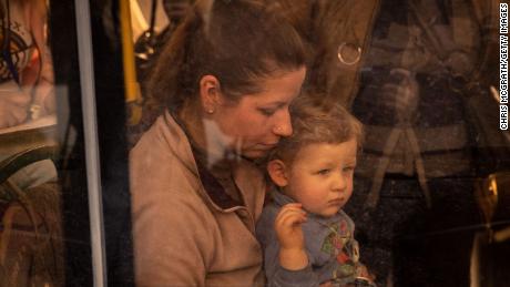 A woman sits with a child on an evacuation bus after fleeing the Azovstal plant in Mariupol.