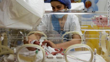 A nurse takes care of one of the newborn nonuplets, lying in an incubator, at the Ain Borja in Casablanca on May 5, 2021.