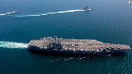 The USS Abraham Lincoln, 正面, and other warships sail in formation during a US-Japan bilateral exercise.