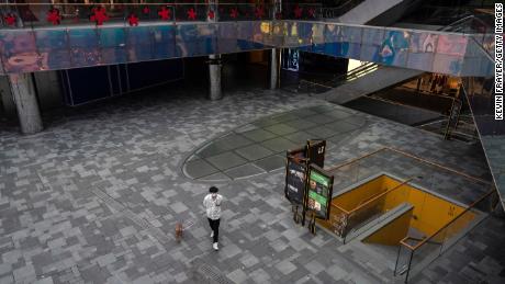 A man walks his dog through the nearly empty courtyard of the usually bustling Taikoo Li mall in Sanlitun after many retail stores were closed to help prevent the spread of COVID-19 on May 10, 2022 베이징에서, 중국. 