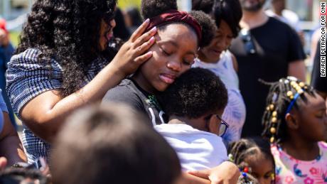 People surround Deazjah Roseboro, 12, as she comforts her 8-year-old cousin, Jerney Moss.