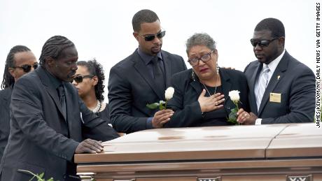 Sharon Risher, 2nd from right, and Gary Washington, 左, pay their respects at the casket of their mother, Ethel Lance, 70, before her burial at the AME Church cemetery on Thursday, 六月 25, 2015 in North Charleston, S.C.  