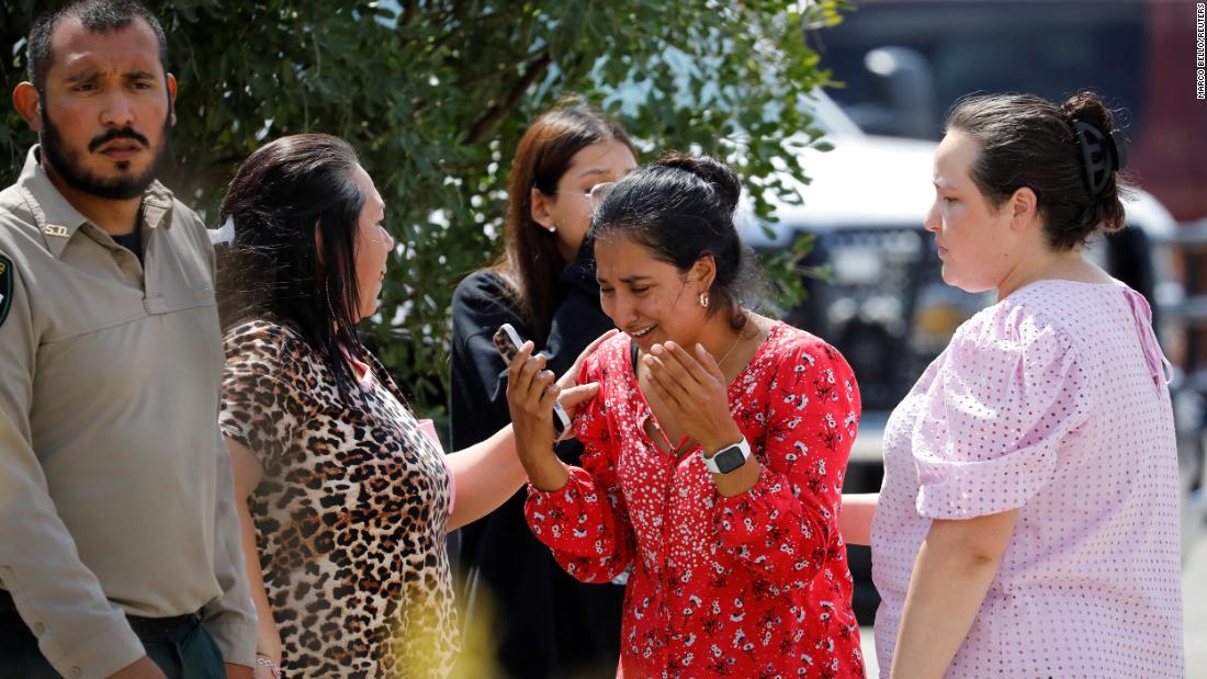 A woman reacts Tuesday outside of the civic center in Uvalde.