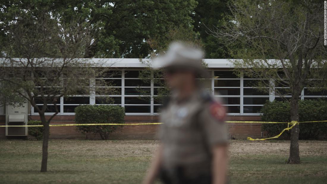 A Texas state trooper walks outside Robb Elementary School, where the shooting took place.