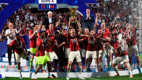 Alessio Romagnoli (センター) of AC Milan lifts the Scudetto trophy as his teammates celebrate during the Serie A award ceremony.