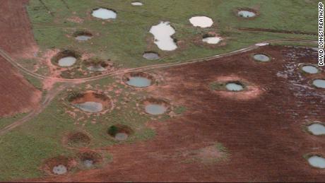 What appear to be ponds are actually water-filled bomb craters from the Vietnam War era, as seen from a helicopter, 할 수있다 25, 1997, near the northeastern Laotian village of Sam Neau.